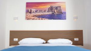 a bedroom with a bed and a painting on the wall at Little Suites Pompeii in Torre Annunziata
