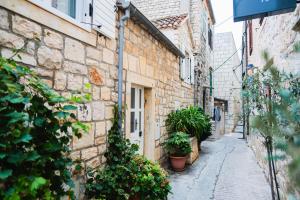 eine Gasse in einem alten Steingebäude mit Topfpflanzen in der Unterkunft Blu Riva Hvar in Hvar + 13 Fotos