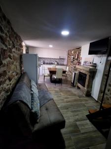 a living room with a couch in front of a kitchen at A Casa da Aldeia 1 Belmonte in Gaia