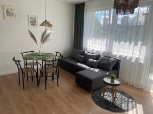 een woonkamer met een bank en een tafel bij Apartament Cichy in Tarnów