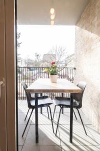 a table and chairs on a balcony with a plant at Appart Le Lully in Versailles