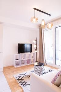 a living room with a white couch and a tv at Appart Le Lully in Versailles
