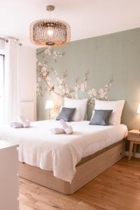 a bedroom with a large bed with flowers on the wall at Appart Le Lully in Versailles