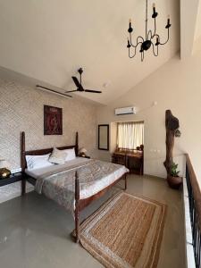 a bedroom with a bed and a chandelier at Saanjh-Kudrats Nilaya in Canacona +18 photos