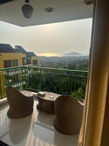 a balcony with a table and chairs and a view at Saanjh-Kudrats Nilaya in Canacona