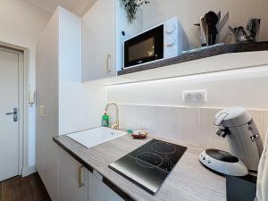 a kitchen with a counter with a sink and a appliance at Le cocon chatelain in Bréviandes