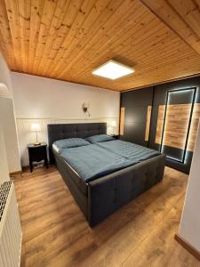 sypialnia z dużym łóżkiem i drewnianym sufitem w obiekcie Ferienwohnung Dörfl in Glödnitz, Carinthia w mieście Glödnitz
