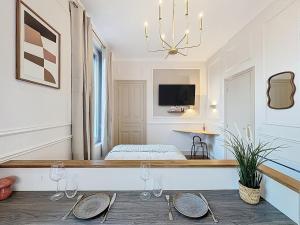 a room with a bed and a table with wine glasses at Le cocon chatelain in Bréviandes