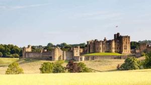 a large castle sitting on top of a field at 7 dodds lane alnwick in Alnwick