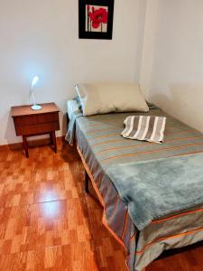 a room with two beds and a table with a lamp at Hogar in Alicante