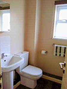 a bathroom with a white toilet and a sink at Bungalow in Cambridge- 3 bedrooms in CBG
