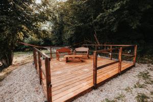 a wooden deck with a bench and a table at Teepee Svištící šíp  +14 photos