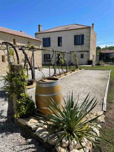 a large barrel in front of a house at Chambres au cœur des vignes in Saint-Christoly-Médoc +6 photos
