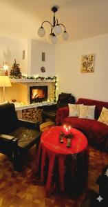 a living room with a fireplace and a red table with candles at Willa Szymusiowa Szczyrk Pokoje i Apartamenty Przy Gondoli in Szczyrk