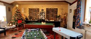 ein Raum mit einem Weihnachtsbaum und Tischtennisplatten in der Unterkunft Willa Szymusiowa Szczyrk Pokoje i Apartamenty Przy Gondoli in Szczyrk
