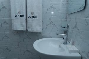 a bathroom with a sink and towels on a wall at Amoria Boutique Hotel in Kiambu