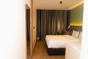 a hotel room with a bed and a large window at Amoria Boutique Hotel in Kiambu