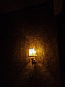 a lamp on a wall in a room at Tetebatu River Side BUNGALOWs in Tetebatu