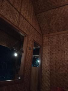 a room with a brick wall and a window with lights at Tetebatu River Side BUNGALOWs in Tetebatu +3 photos