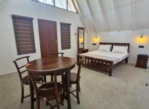 a bedroom with a bed and a table and chairs at Pearl Crown Paradise room to rent Negombo in Negombo