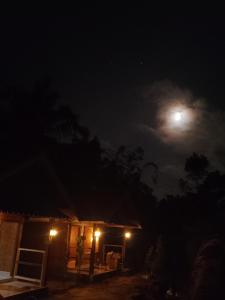 a house at night with the moon in the sky at Tetebatu River Side BUNGALOWs in Tetebatu