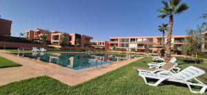 a resort with a swimming pool with two lawn chairs at Domaine de noria in Marrakesh