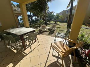 a patio with a table and chairs on a porch at Palmar Bay - Beachside Villa in Palmar +40 photos