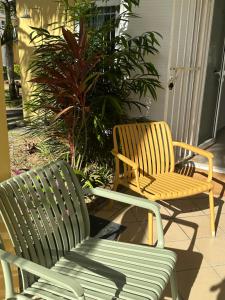 two chairs and a bench on a porch at Palmar Bay - Beachside Villa in Palmar