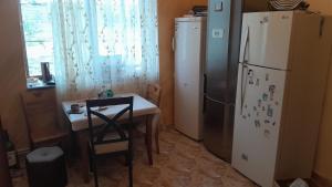 a kitchen with a table and a refrigerator at Агарод in Atʼarbekyan