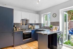 a kitchen with white cabinets and blue counters at Modern House in Haydock with FREE Parking & Garden Patio in Haydock
