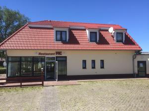 a white building with a red roof and a door at Pension in Warin