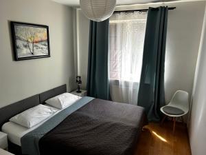 a bedroom with a bed and a window at Kasztanowa Apartament in Warsaw