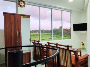 a balcony with two chairs and a large window at ANTONIO TRANSIT KATUNAYAKE in Katunayaka