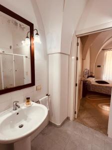 a bathroom with a sink and a mirror and a bedroom at Villa Raffaella in Santa Cesarea Terme