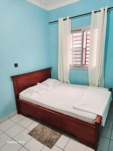 ヤウンデにあるClimatisation - Wi-Fi gratuitの窓付きの青い部屋のベッド1台