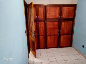 ヤウンデにあるClimatisation - Wi-Fi gratuitの木製のキャビネット付きのキッチンへの開放ドア