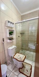 a bathroom with a toilet and a glass shower at Serraruna House no centro histórico in Araruna +19 photos