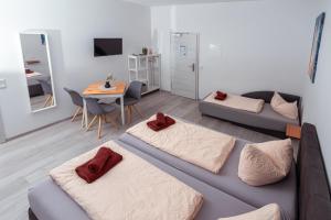 a living room with two beds and a table at Zum Obstler - Gaststätte und Pension in Gera