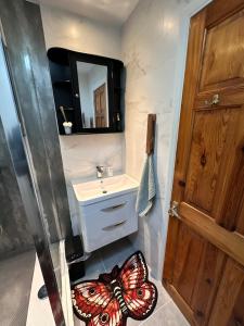 un bagno con un tappeto a farfalla accanto a un lavandino di Heart of Windsor a Windsor