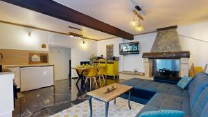 a living room with a blue couch and a fireplace at Maison Spa Sauna Proche du Lac in Brive-la-Gaillarde