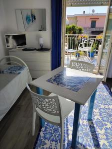 a table and chairs in a room with a balcony at Casa Azzurra in Ginosa Marina