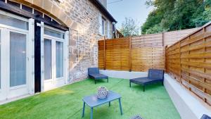 ブリーヴ・ラ・ガイヤルドにあるMaison Spa Sauna Proche du Lacのパティオ(椅子2脚、芝生の上にテーブル付)
