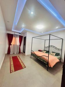 a bedroom with a canopy bed with a red rug at Appartement Moderne, Climatisé, 2 chambres à Ouakam - Dakar, près du Monument de la Renaissance in Dakar