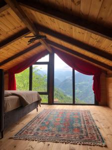 a bedroom with a bed and a large window at Ta En Tepe in Çamlıhemşin
