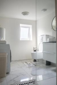 Un baño blanco con inodoro y ventana. en Literie d'exception, luxe calme et confort, en Rouen 57 fotos más