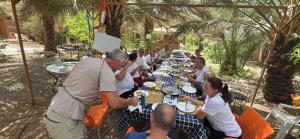a group of people sitting at a long table at Maison d'hôte Riad Todra in Tinerhir