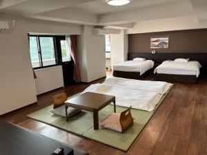 een hotelkamer met twee bedden en een tafel bij City Pension Zem in Tokyo