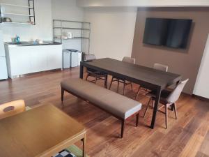 a dining room with a black table and chairs at City Pension Zem in Tokyo