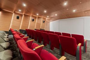 a lecture room with red chairs and a screen at Stylish 2BR Loft with Top-Tier Amenities - 104 - GL in Glendale +33 photos