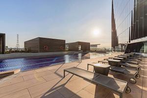 einen Pool auf dem Dach eines Gebäudes mit Stühlen in der Unterkunft Luxury Marina Tower Stay Waterfront & City Views in Melbourne